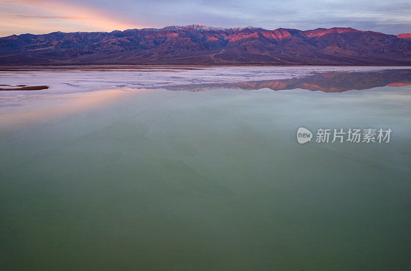 加利福尼亚死亡谷国家公园Bad water Basin的日出，望远镜山和它们的倒影。坏水盆地盐滩